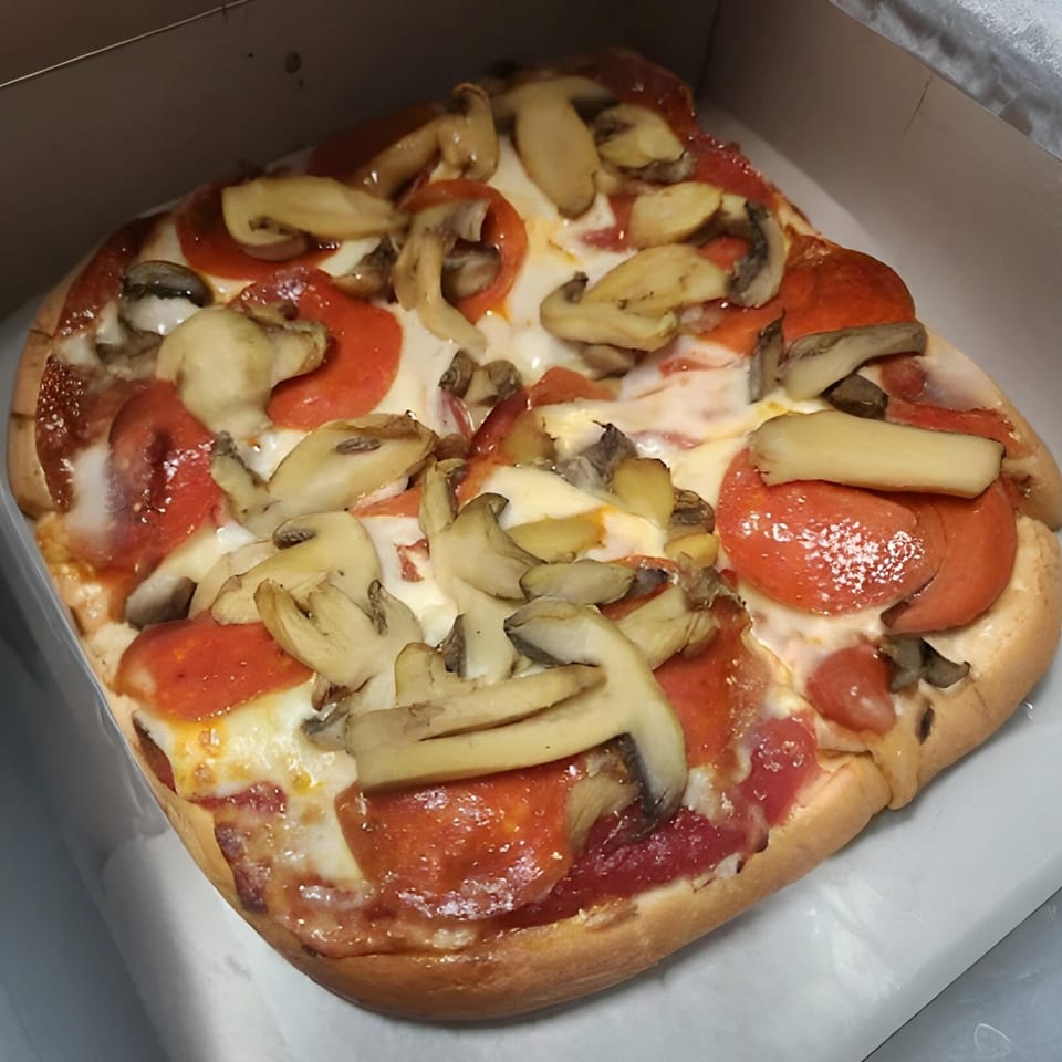 Al's Pizza pepperoni and mushroom pizza, with melted cheese and red sauce, in a white box.