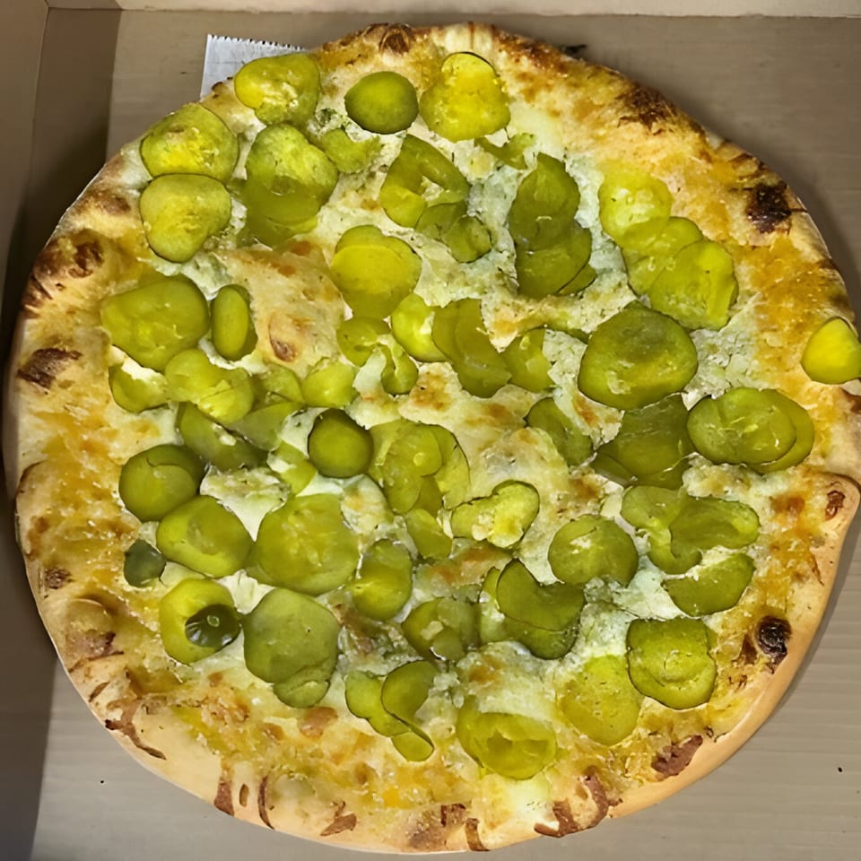 Al's Pizza's whole pickle pizza, topped with melted cheese and sliced green pickles.