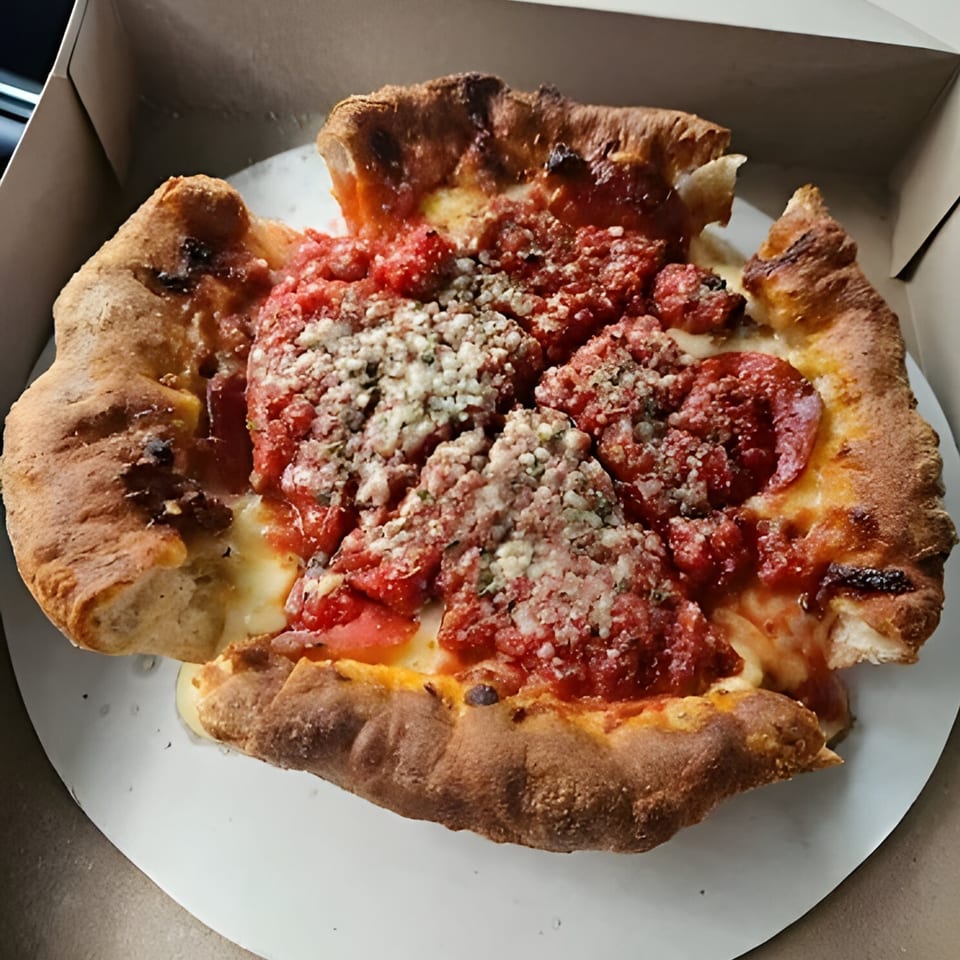 A deep-dish Al's Pizza with thick crust, rich red sauce, and grated cheese in a box.