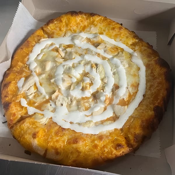 Al's Pizza dessert pizza with white icing swirled over a golden crust and almond slivers.