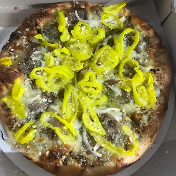 Al's Pizza with banana peppers, onions, and meat, dusted with parmesan cheese in a box.