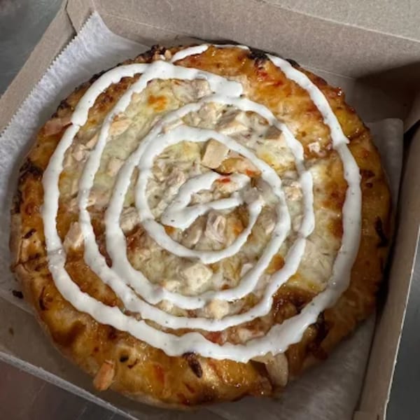Al's Pizza's chicken pizza with a spiral of white sauce in a cardboard box.